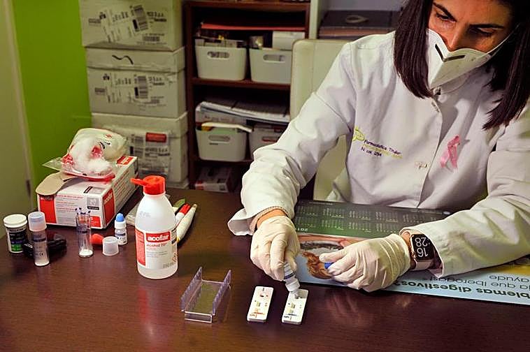 Una farmacéutica añade el reactivo a una placa en un test