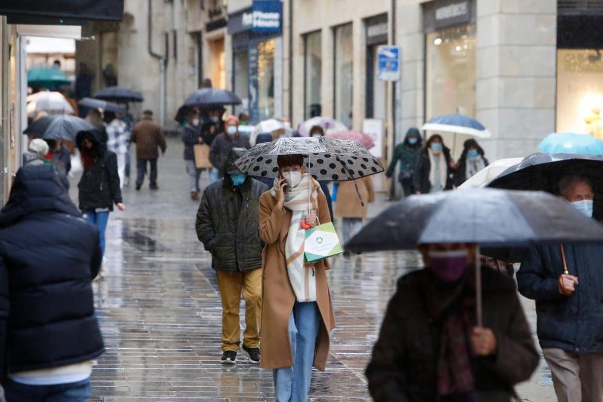 Gente con paraguas en una calle céntrica de Salamanca.