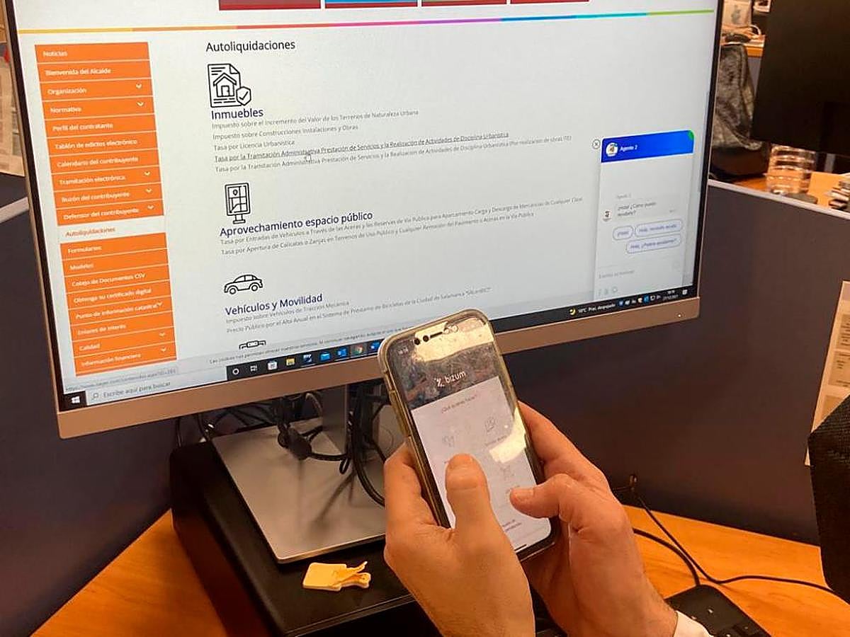 Un ciudadano consulta su app de bizum y la web del Oager.