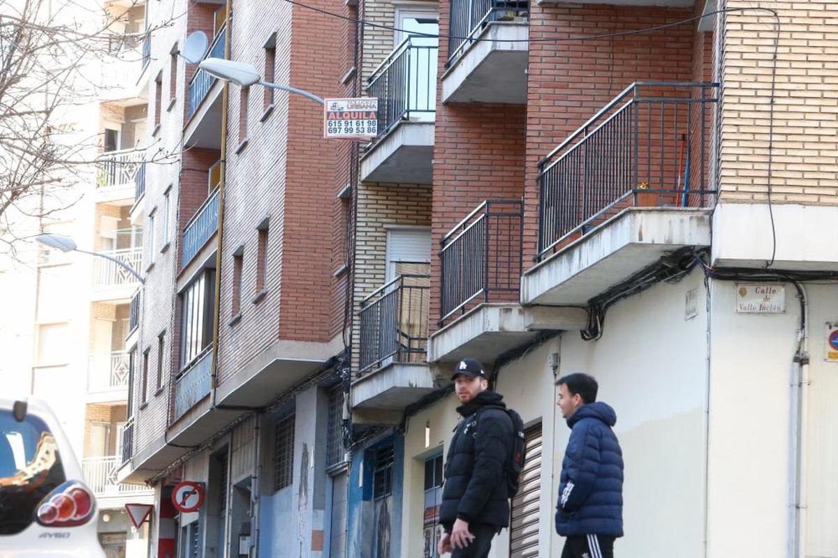 Dos jóvenes pasan por delante de uno de los pisos en alquiler en Salamanca.