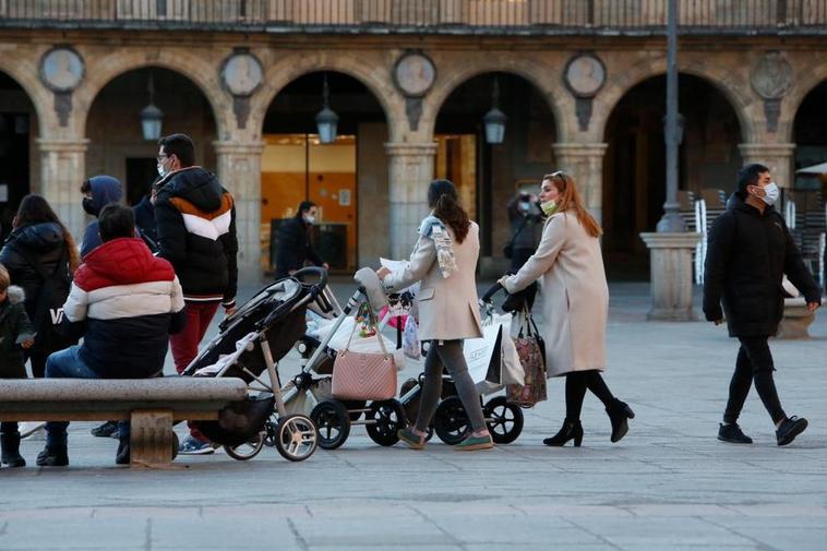 Varias familias paseando a sus hijos pequeños en carritos.