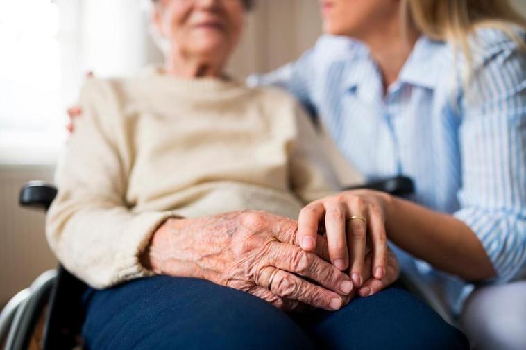 Una anciana, acompañada por una mujer más joven