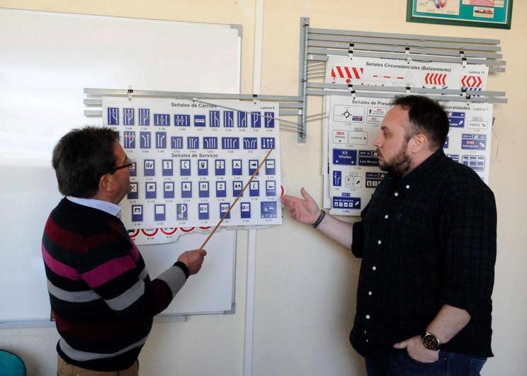 Un profesor de autoescuela muestra las señales.