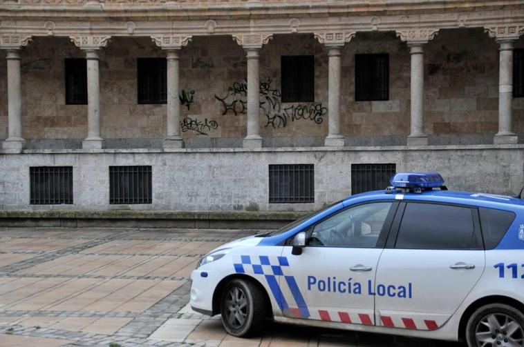 Un coche de la Policía Local ante unas pintadas que aparecieron años atrás en la plaza de San Román.