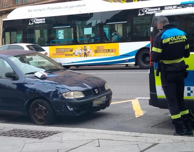 Un agente de la Policía Local junto al vehículo implicado en el accidente.