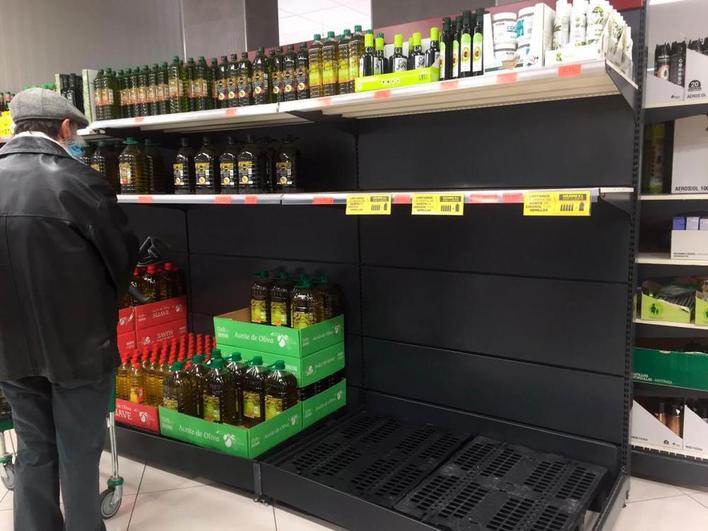 Un hombre junto a un lineal con el apartado de aceite de girasol completamente vacío, en Salamanca.