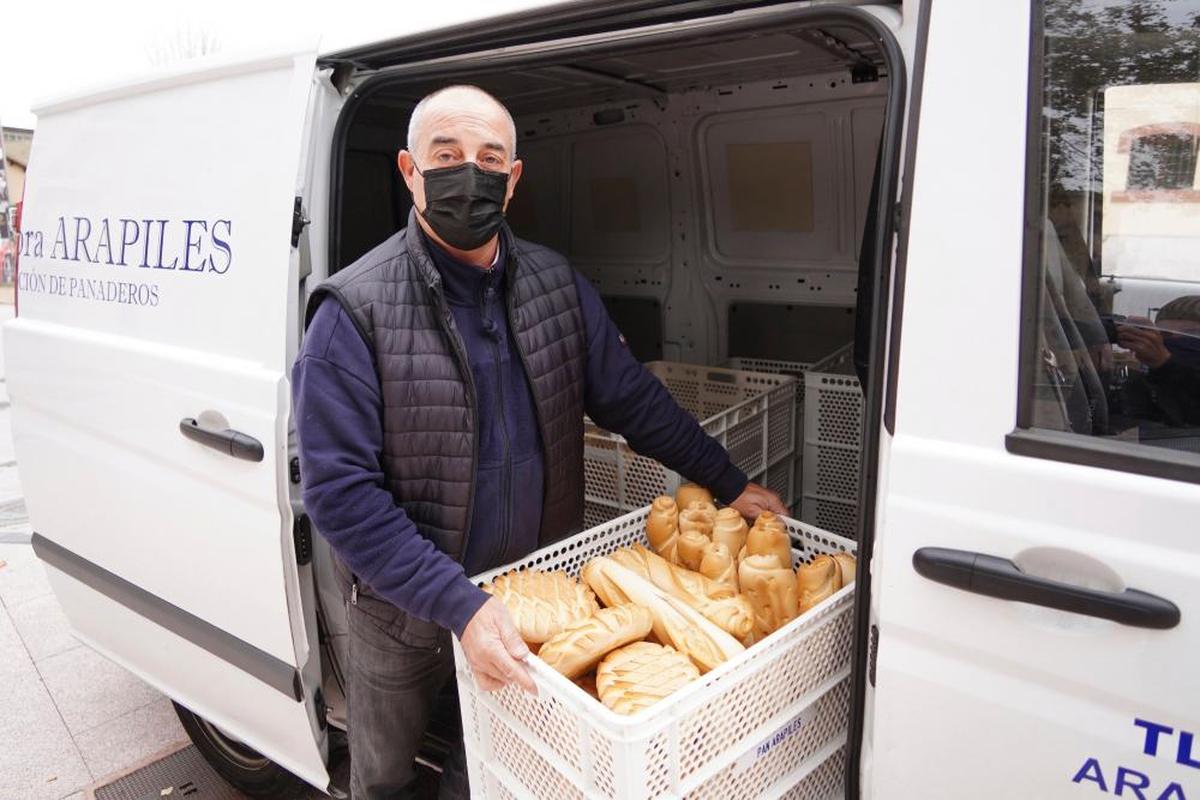 El panadero Joaquín Marcos descarga una cesta de pan de su furgoneta