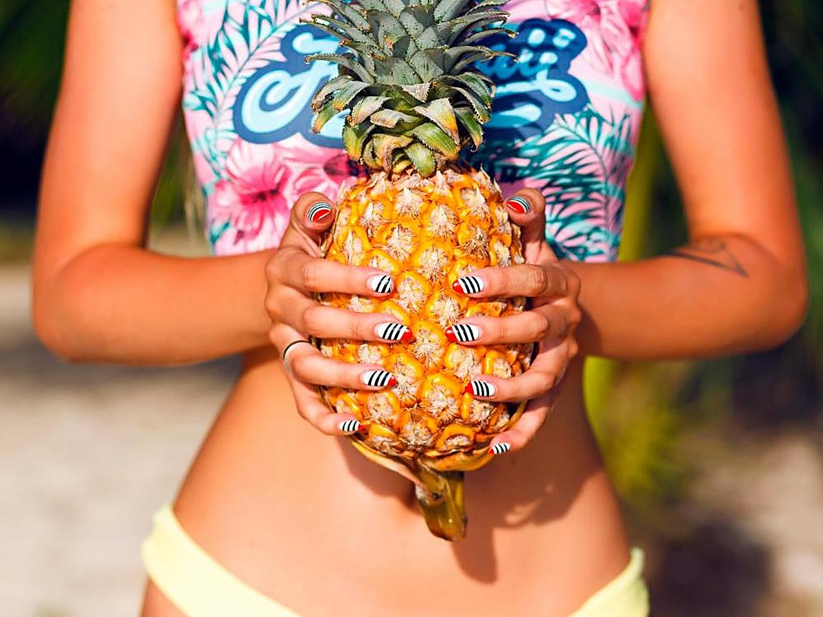 Una mujer sostiene una piña.