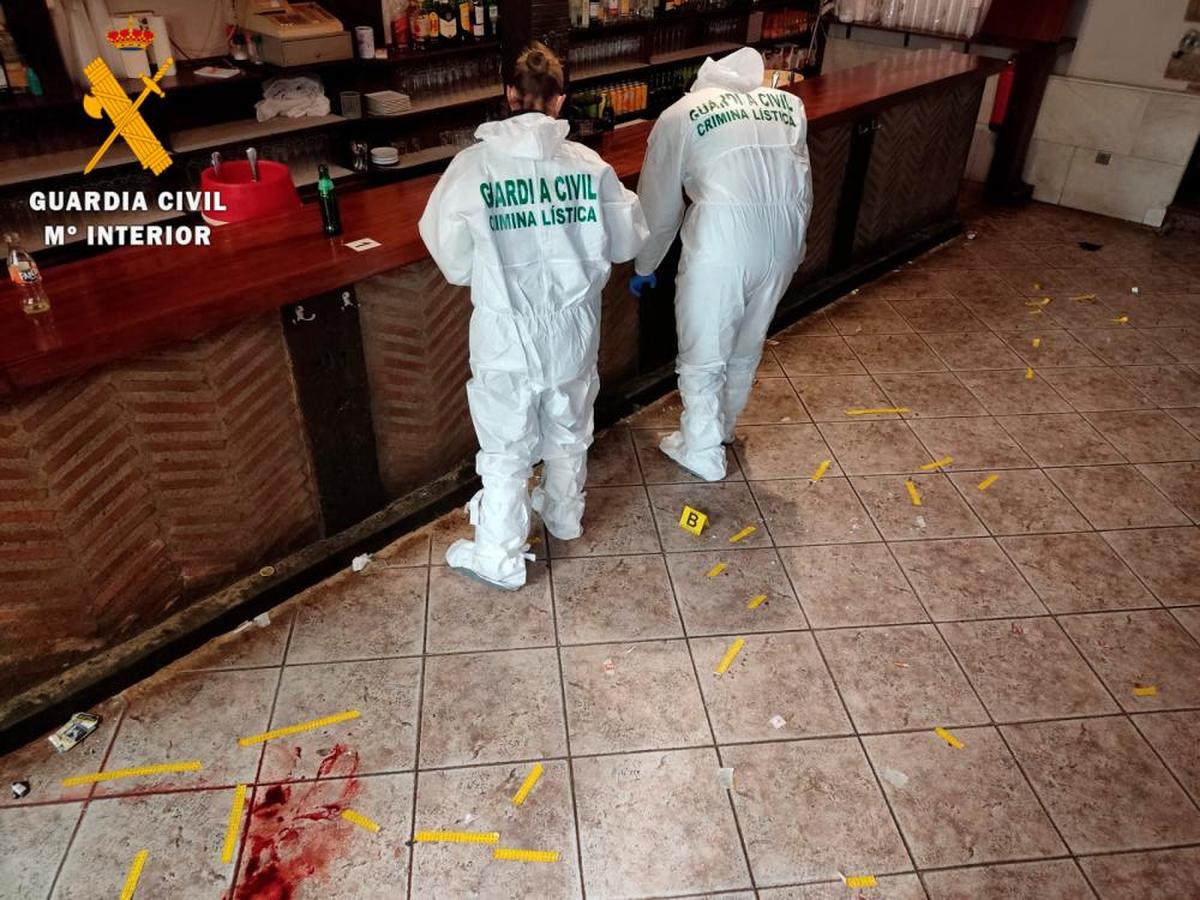 Investigadores inspeccionan el escenario del crimen.