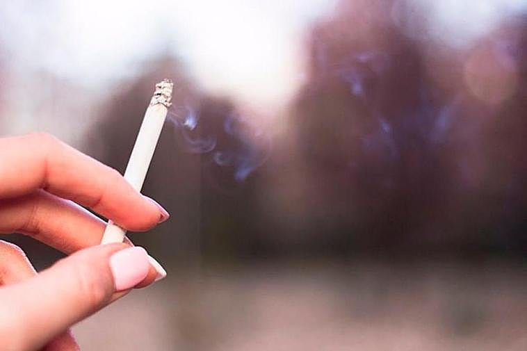 Una persona sujeta un cigarrillo.