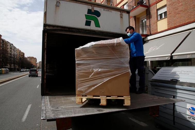 Un transportista descarga un palé en una de las vías principales de Salamanca