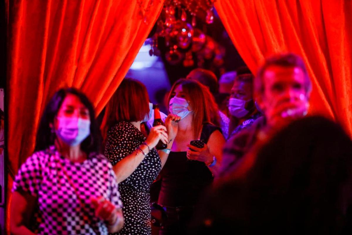 Varias personas con la mascarilla puesta en el interior de un local