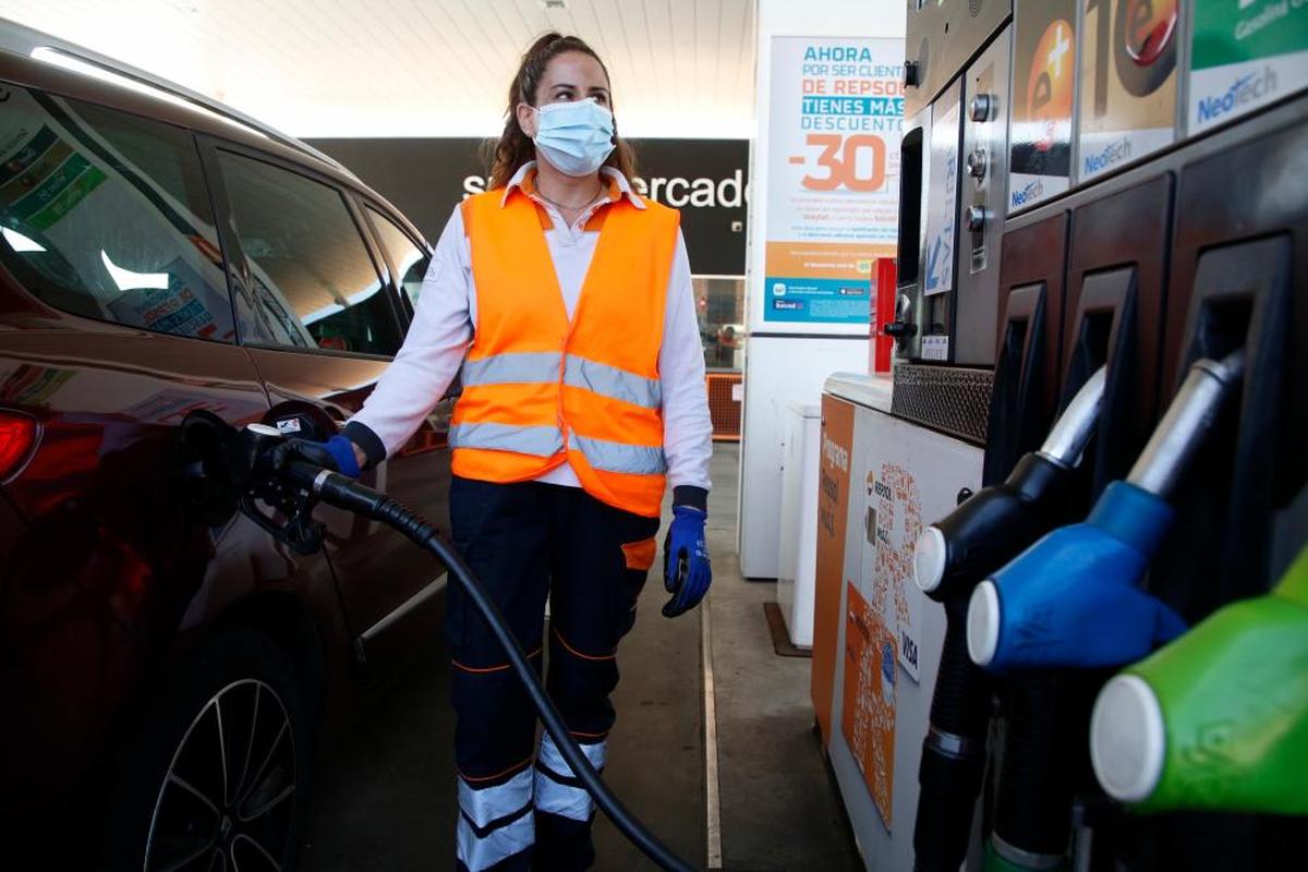 Una empleada de una gasolinera repostando el vehículo de un cliente.