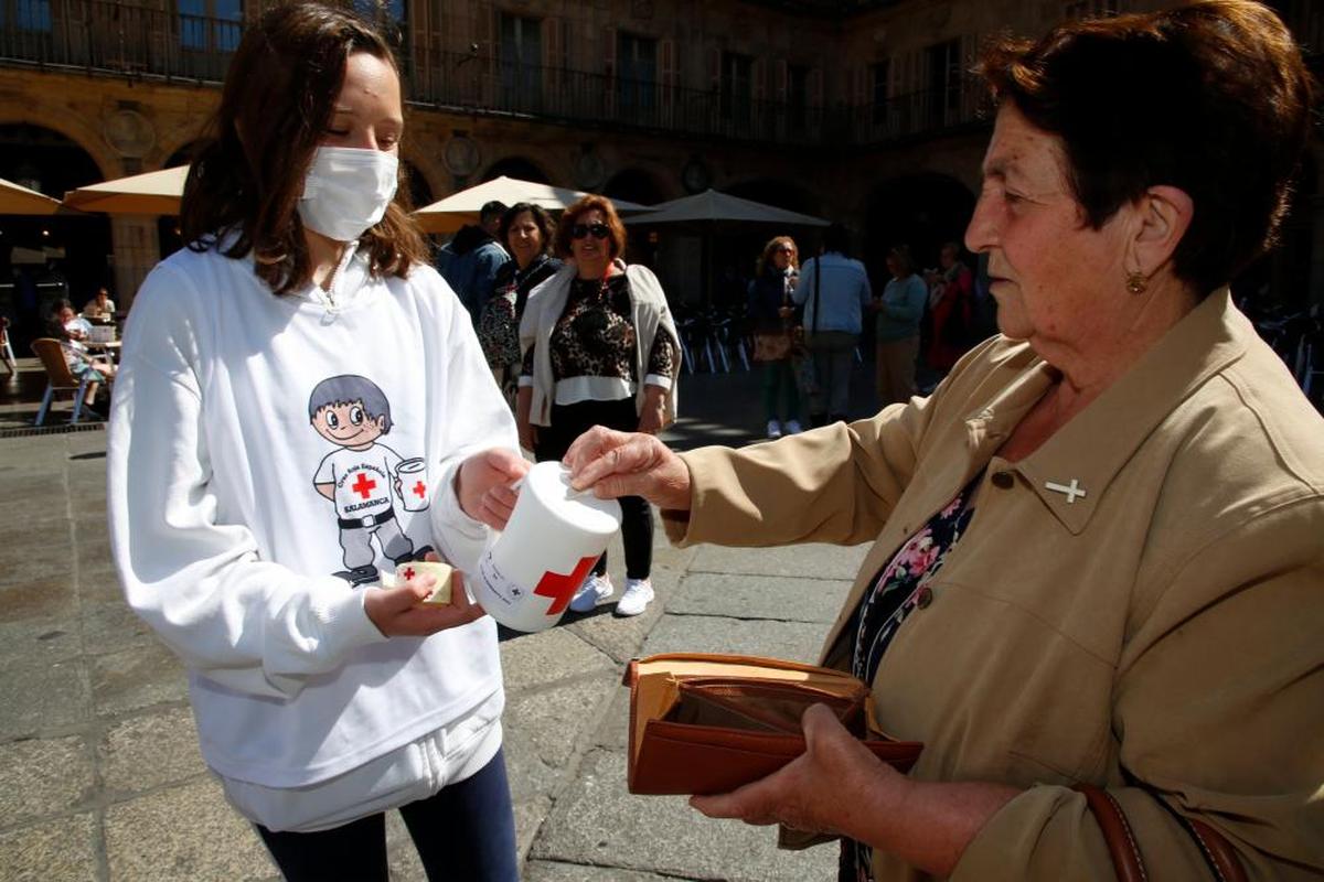 Una señora participa con un donativo en la causa solidaria.