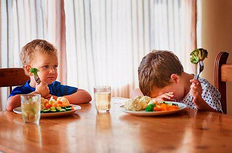 Niños comiendo verduras.