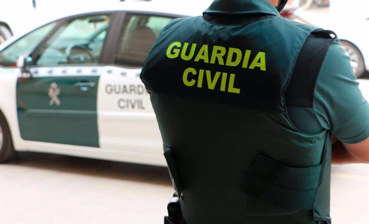 Un agente y una patrulla de la Guardia Civil.