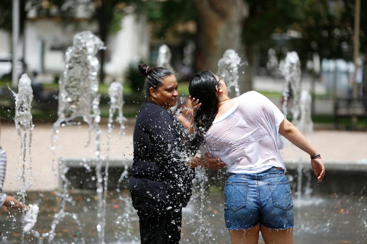 Dos mujeres refrescándose en la fuente de agua de La Alamedilla. I almeida