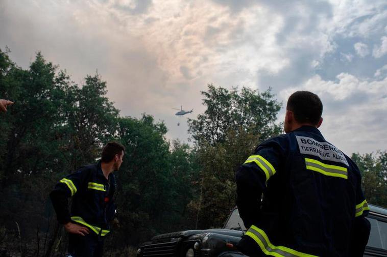 Dos bomberos observan el humo procedente del fuego en la Sierra de la Culebra.