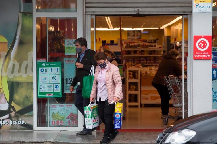 Una mujer sale de un supermercado