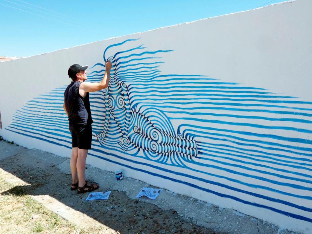El artista Miguel Rodríguez pinta en Rágama el mural “Mujeres espirales en azul”.
