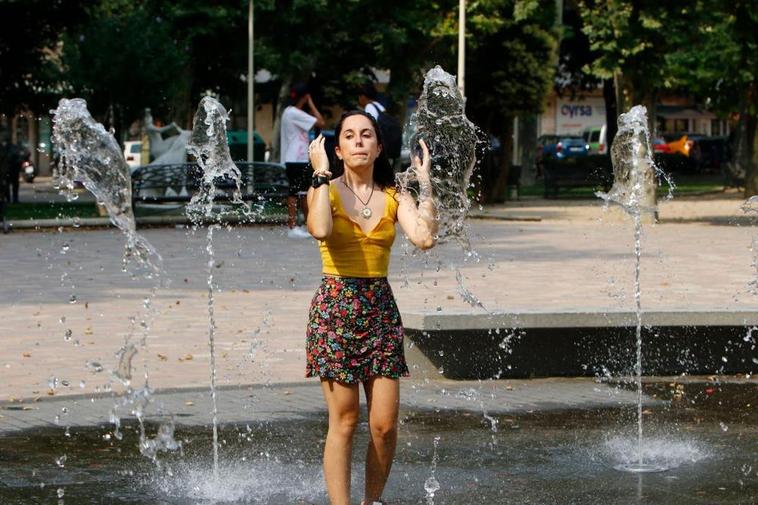 Una joven combate el calor dentro de la fuente de La Alamedilla.