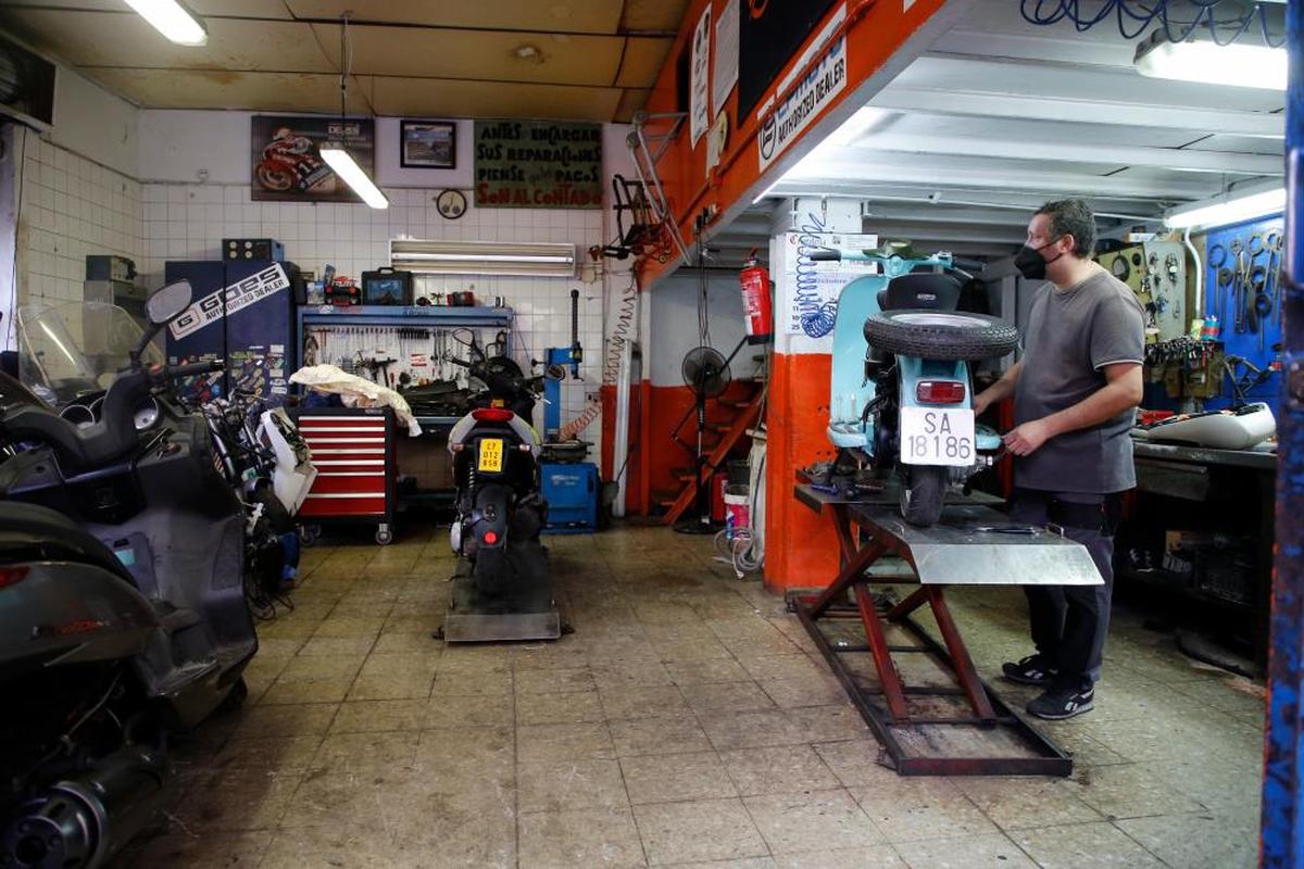 Un autónomo repara una motocicleta en su taller de Salamanca