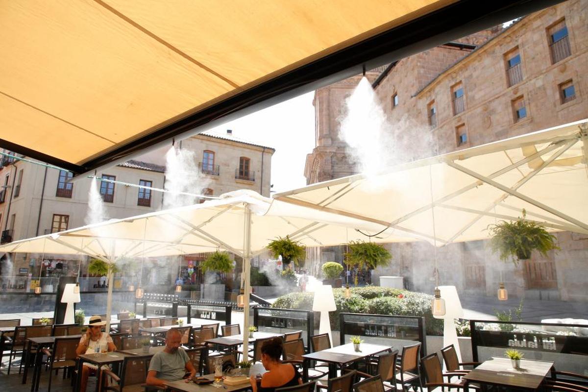 Tres personas sofocan las altas temperaturas en una terraza