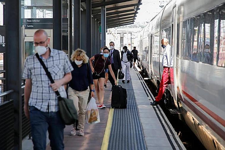 Pasajeros de un tren de Media Distancia procedente de Madrid se bajan en Salamanca.