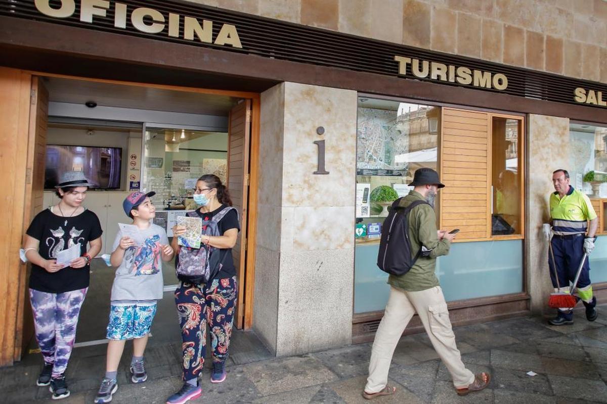 Una familia saliendo de la Oficina Municipal de Turismo de la Plaza Mayor.