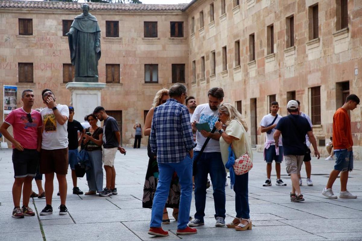 Turistas mirando la fachada de la Universidad en el Patio de Escuelas