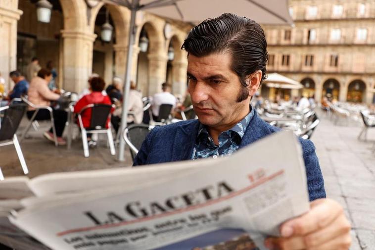 Morante de la Puebla, sentado en la Plaza Mayor, leyendo la crónica de su puerta grande en La Glorieta.