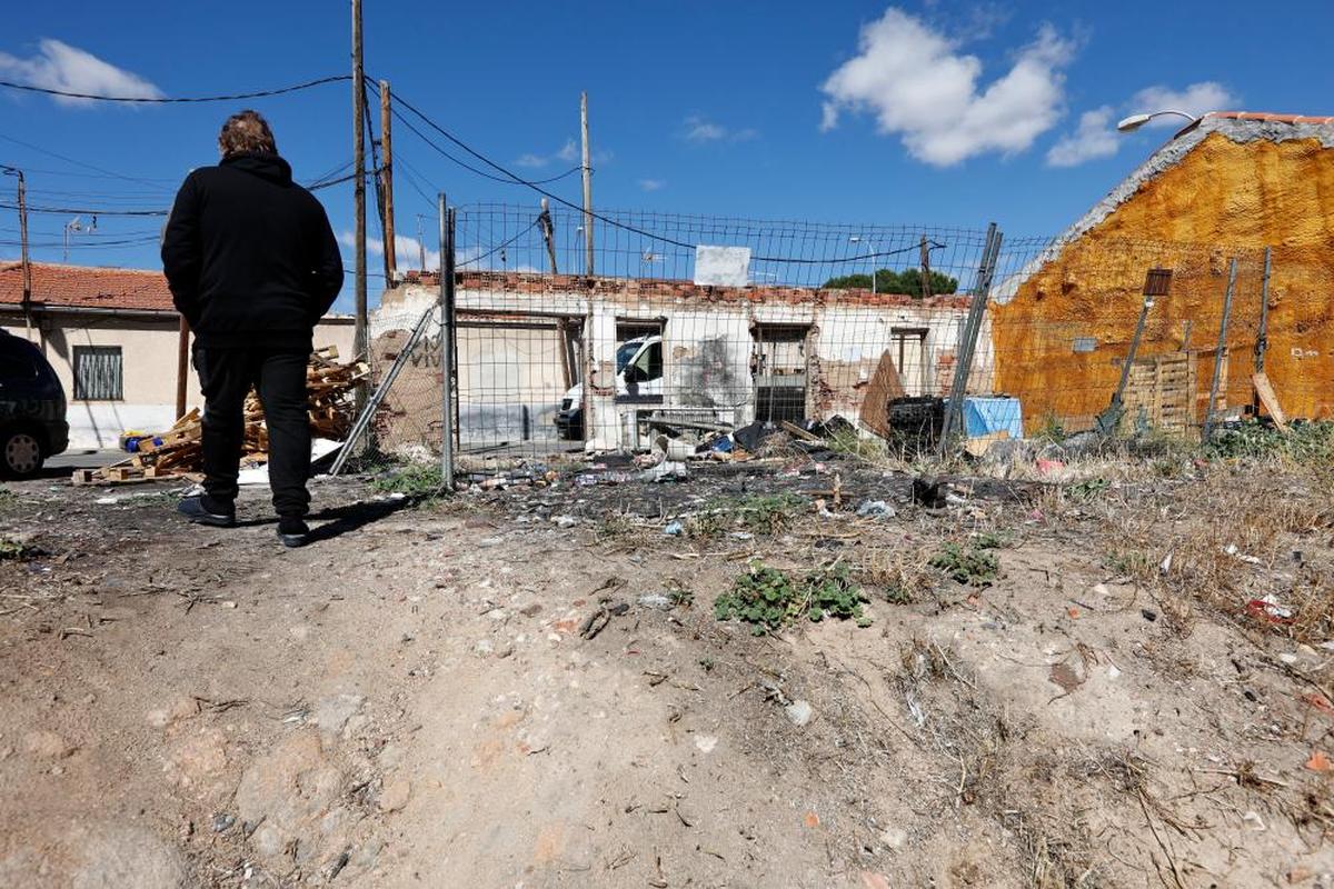 Un vecino paseando por una de las parcelas abandonadas llena de basura y malas hierbas