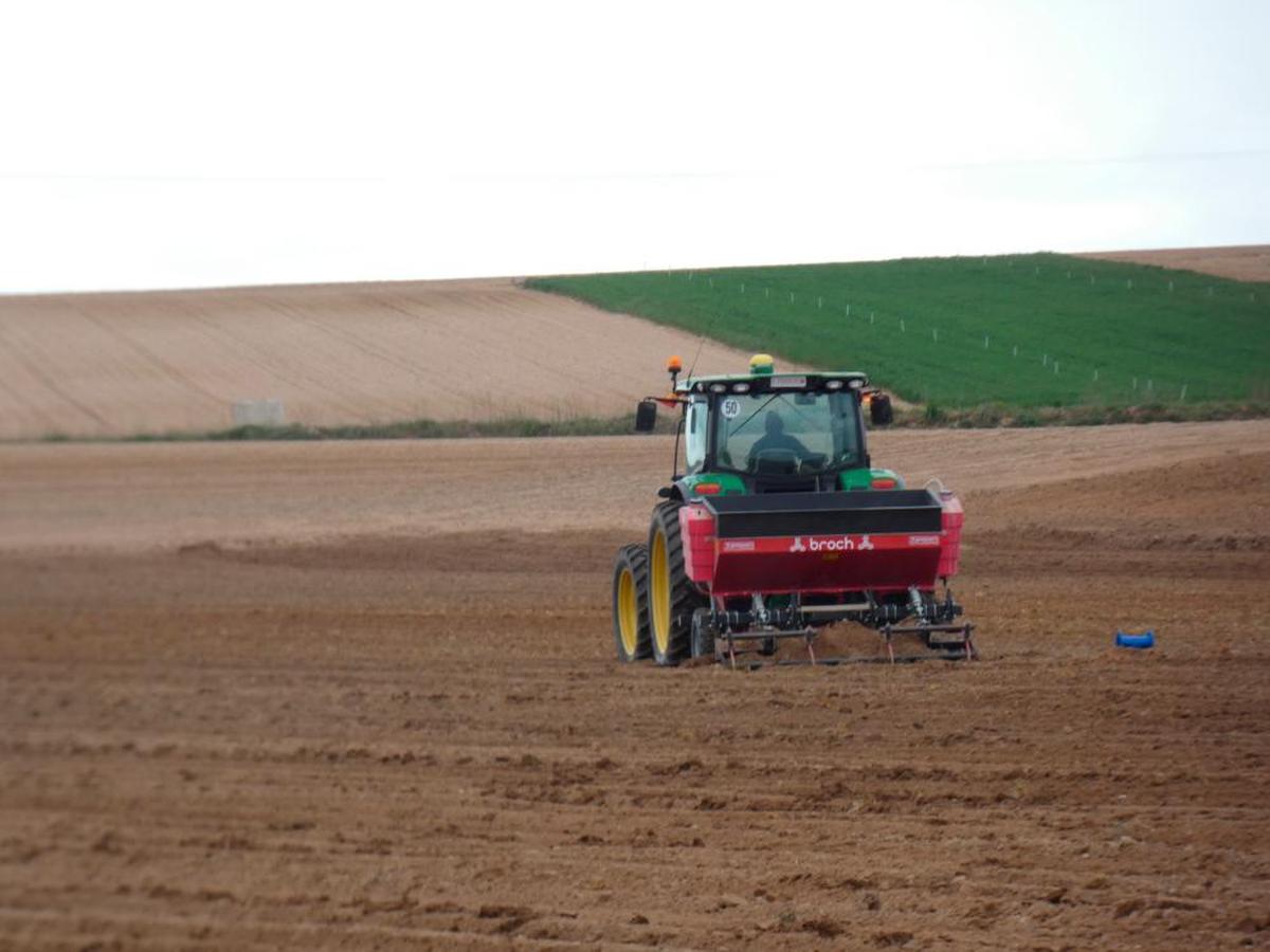 Un agricultor laborea la tierra con su tractor