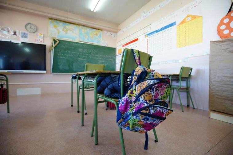 Una mochila, colgada en la silla de un alumno en un centro educativo