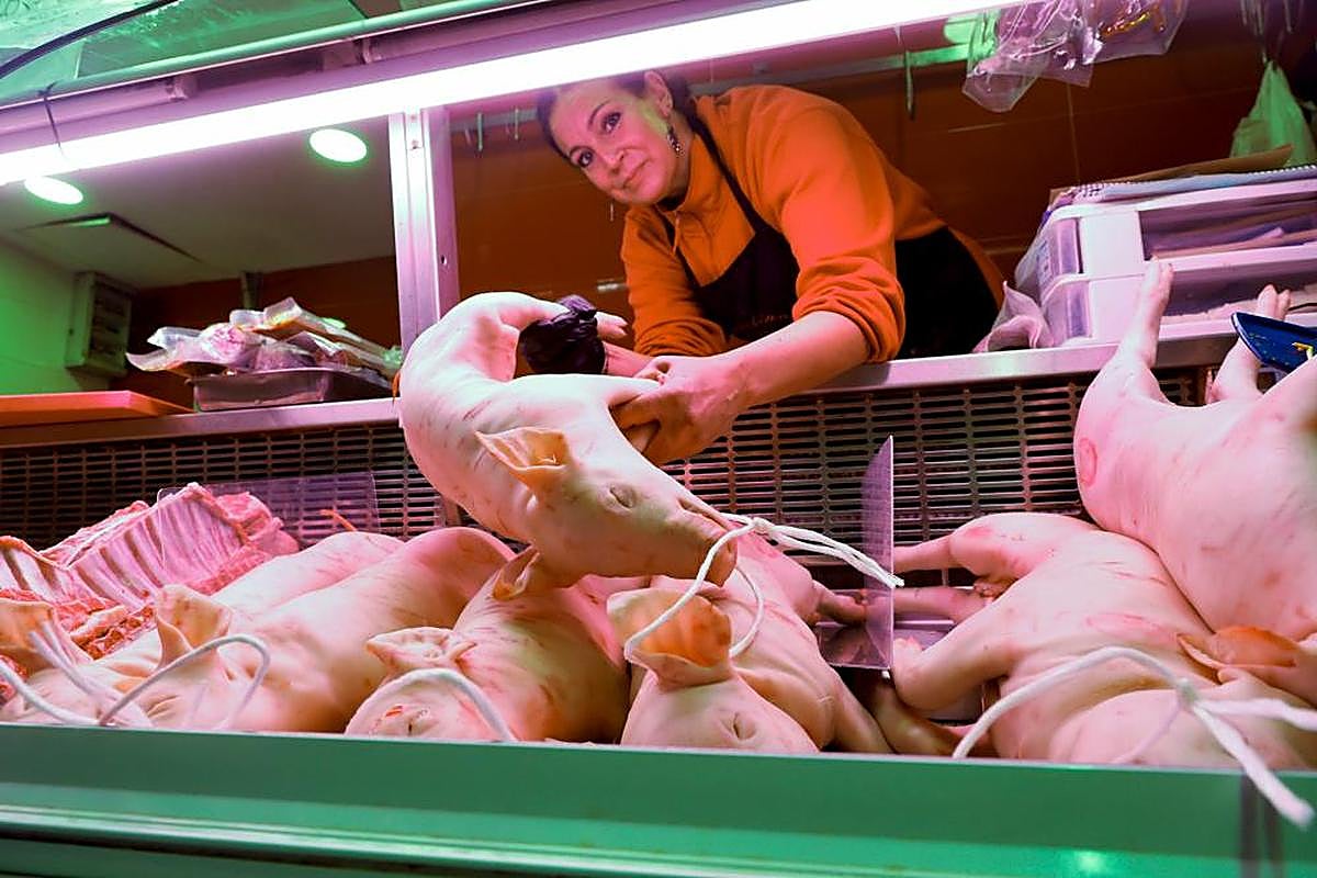 Raquel Macías, en su carnicería, saca tostones de la cámara.  ALMEIDA