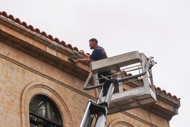 Un albañil repara el alero de un tejado en un edificio de Salamanca