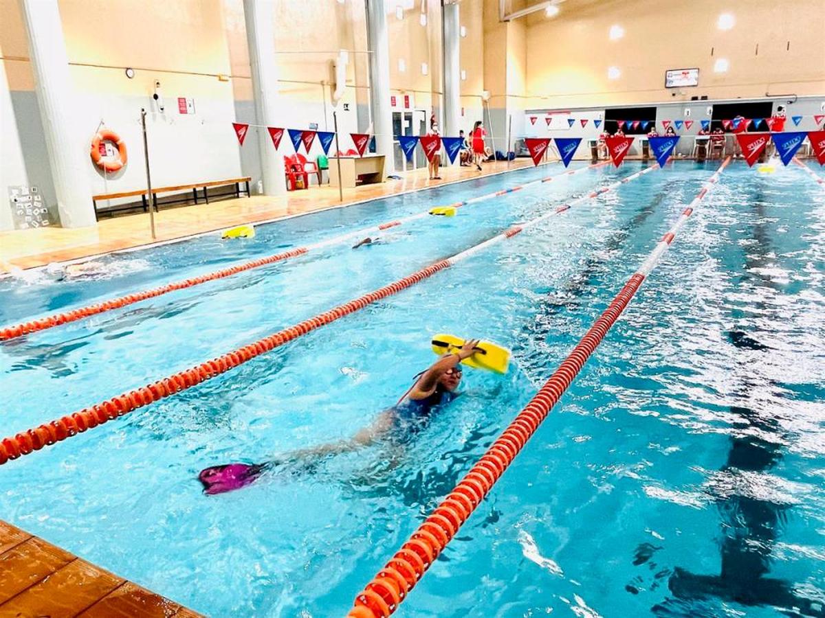 Persona nadando en piscina municipal