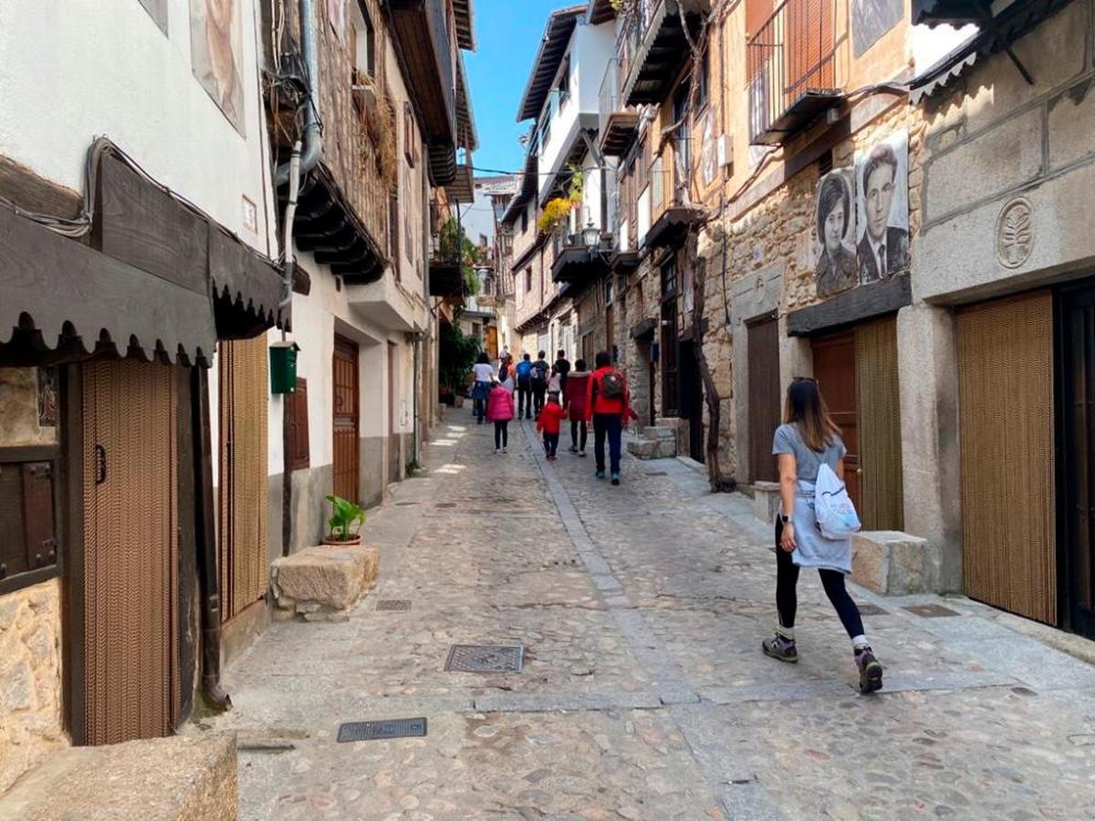 Un grupo de turistas pasea por una de las calles de la localidad de Mogarraz.