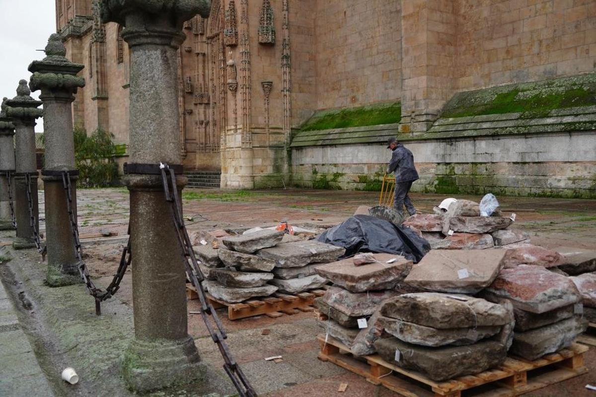 Un trabajador retira una a una las baldosas de granito que conforman el pavimento del atrio