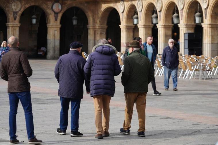 Tres mayores paseando por la Plaza Mayor de Salamanca.