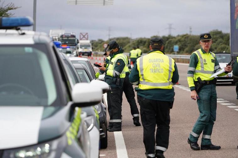 Varios agentes de la Guardia Civil supervisan vehículos en un control.