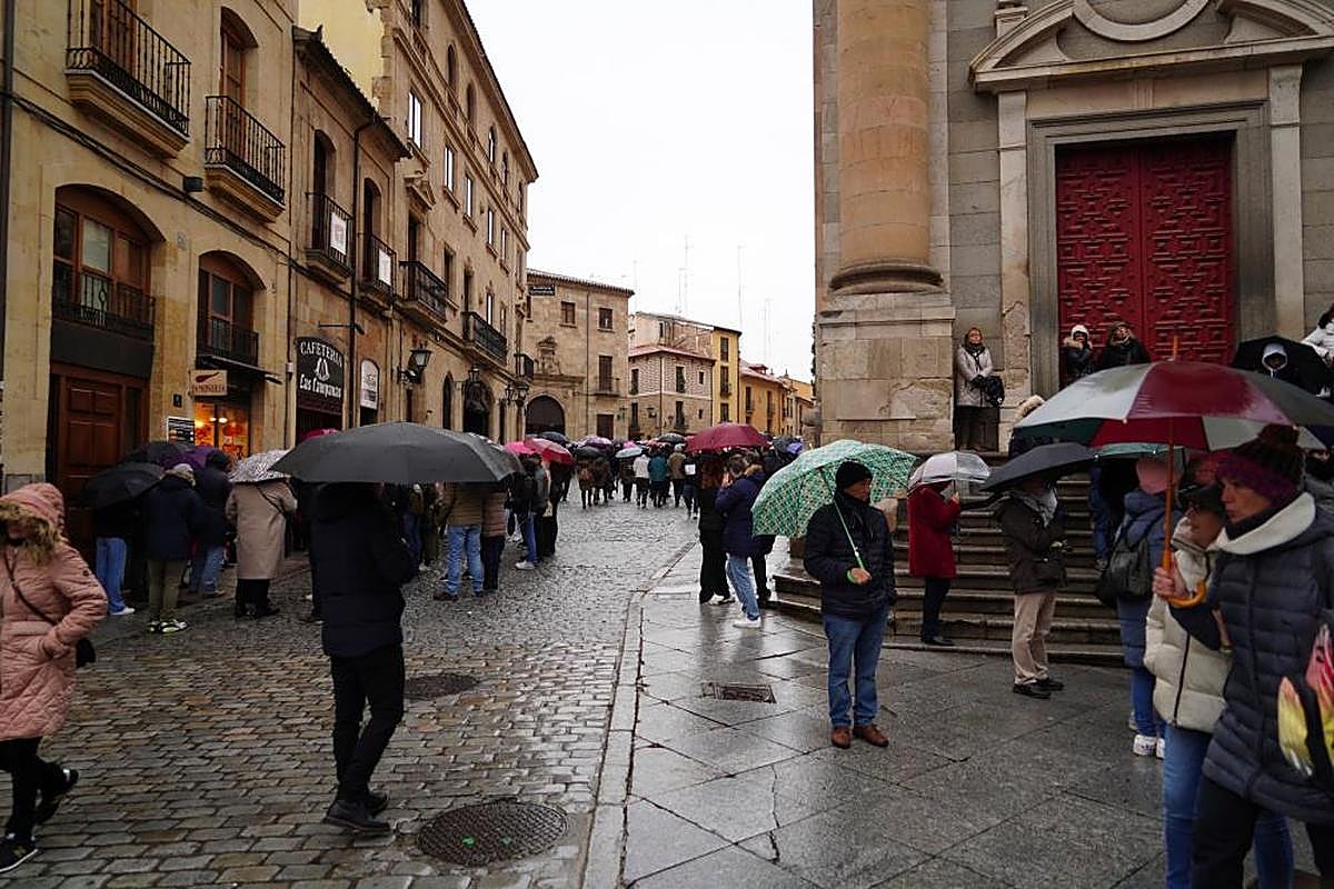 Varias personas caminan por la calle Compañía bajo la lluvia.