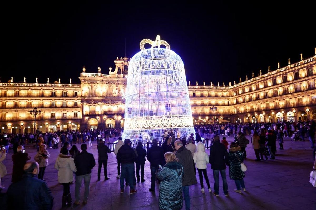 La gente espera alrededor de la campana de la Plaza Mayor para presenciar el espectáculo de música, luces y efectos.