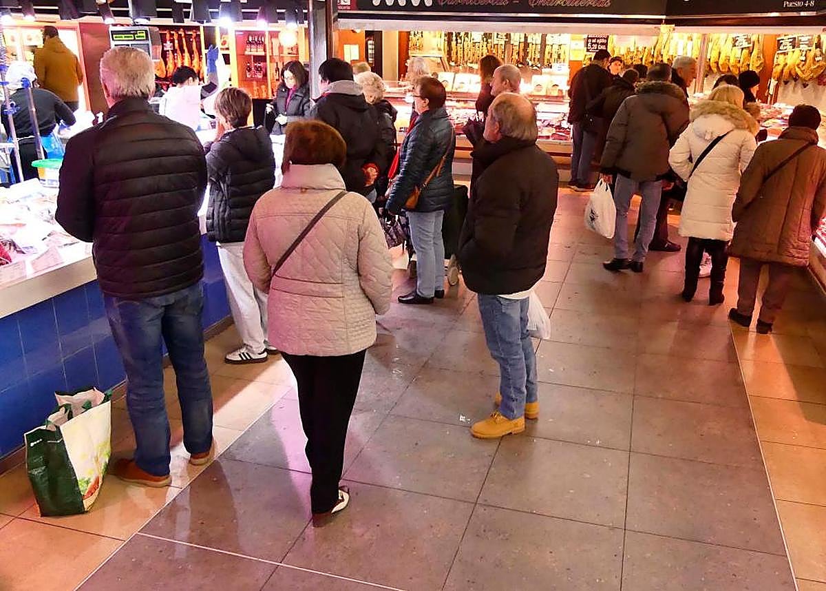 Salmantinos en el mercado de abastos agolpados en una de las pescaderías. GUZÓN