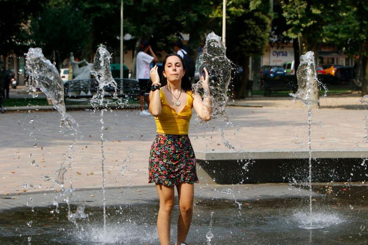 Una joven se refresca durante la ola de calor nunca vista en el mes de julio en Salamanca.