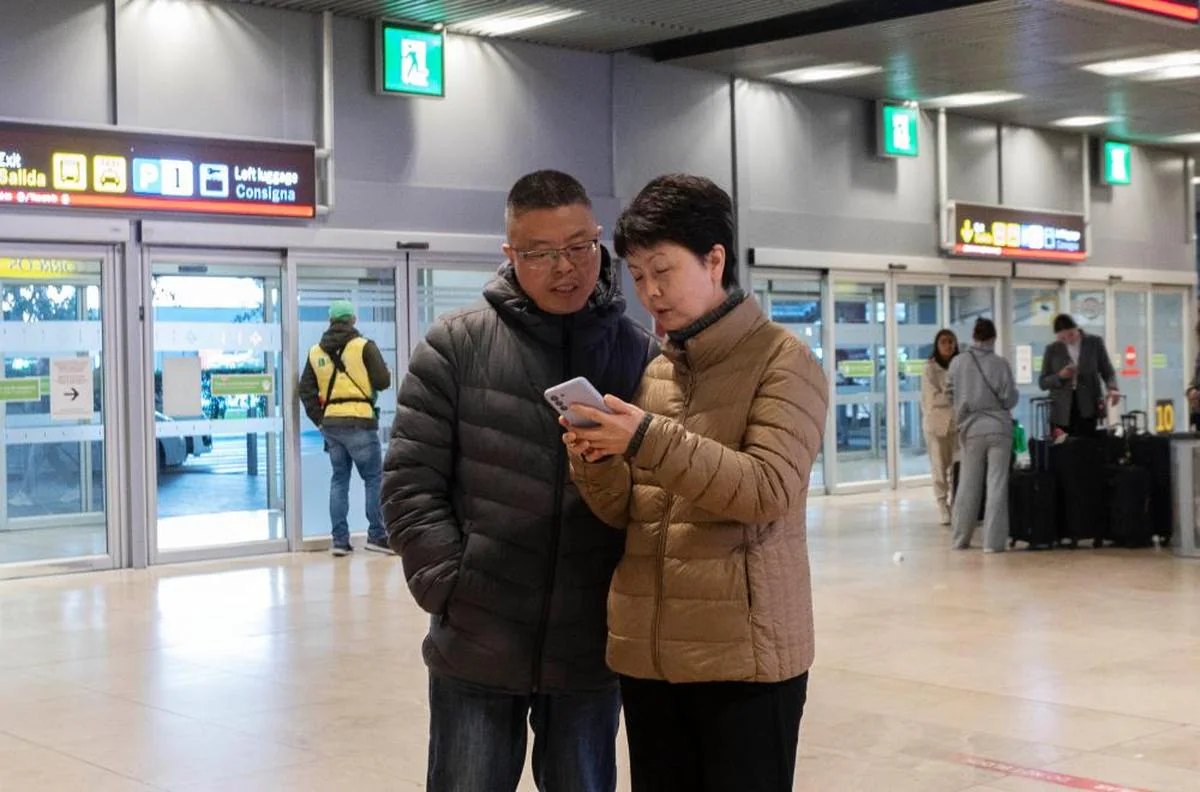 Dos personas esperan la llegada de un vuelo procedente de China