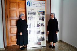 Sor Lilliam y Sor Josefina junto al cartel conmemorativo de los 150 años de las Hermanitas de los Pobres de Salamanca (1872-2022).