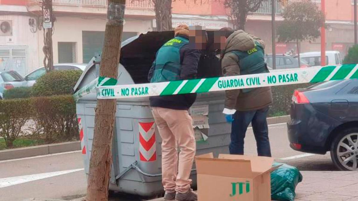 Agentes de la Guardia Civil buscan pruebas de lo ocurrido en un contenedor próximo a la vivienda.