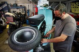 Un trabajador, durante su jornada laboral en su taller de motos