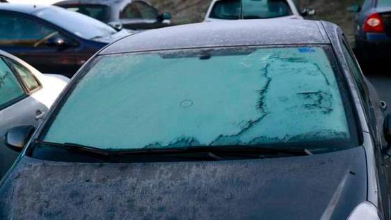 Un coche con la luna completamente congelada.